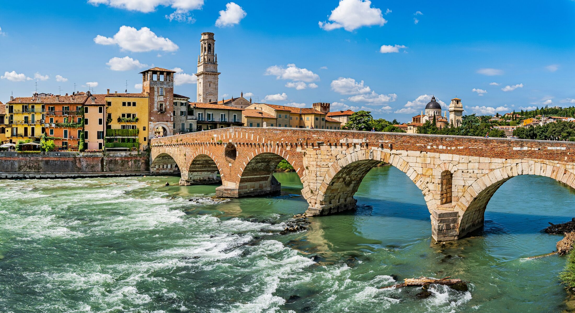 Vista panoramica del Ponte Pietra di Verona con le sue arcate in pietra e mattoni sul fiume Adige.