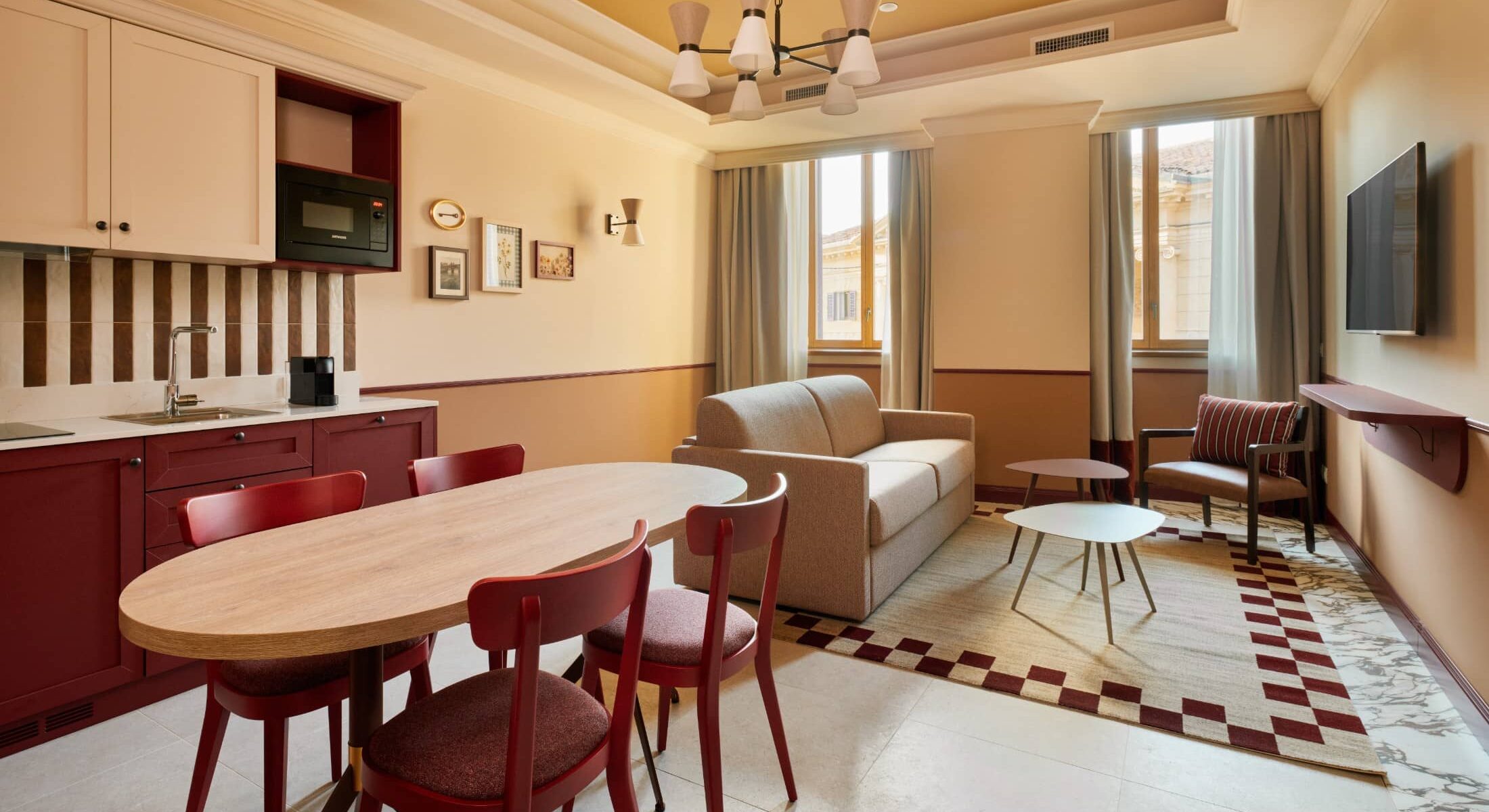 Soggiorno con cucina, tavolo rotondo e sedie rosse – Homy Livia Verona