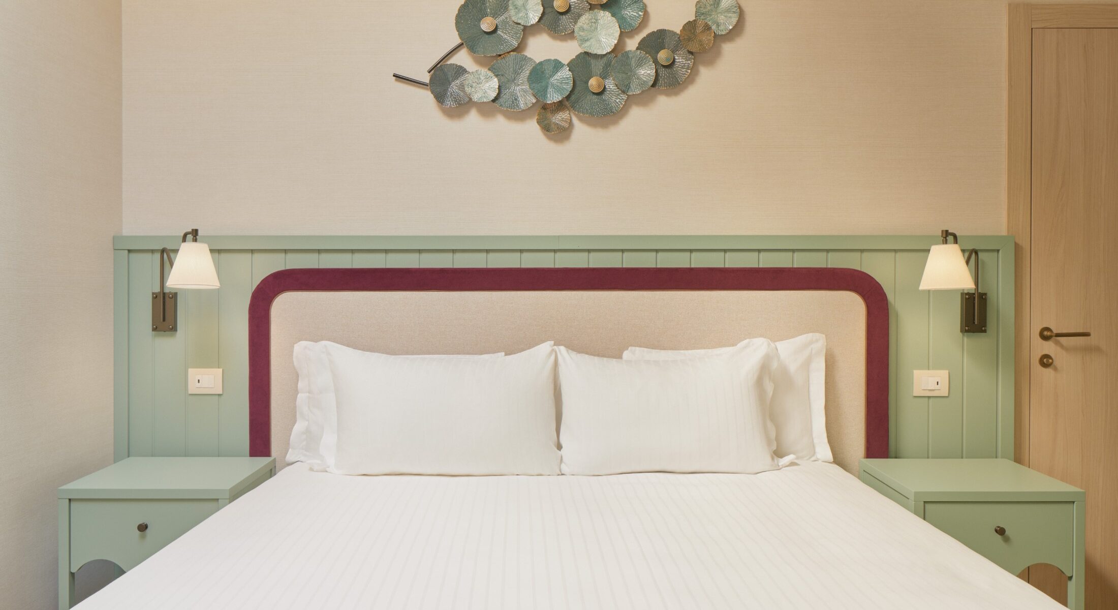 Letto matrimoniale con testata bordeaux e decorazione murale – Homy Livia Verona