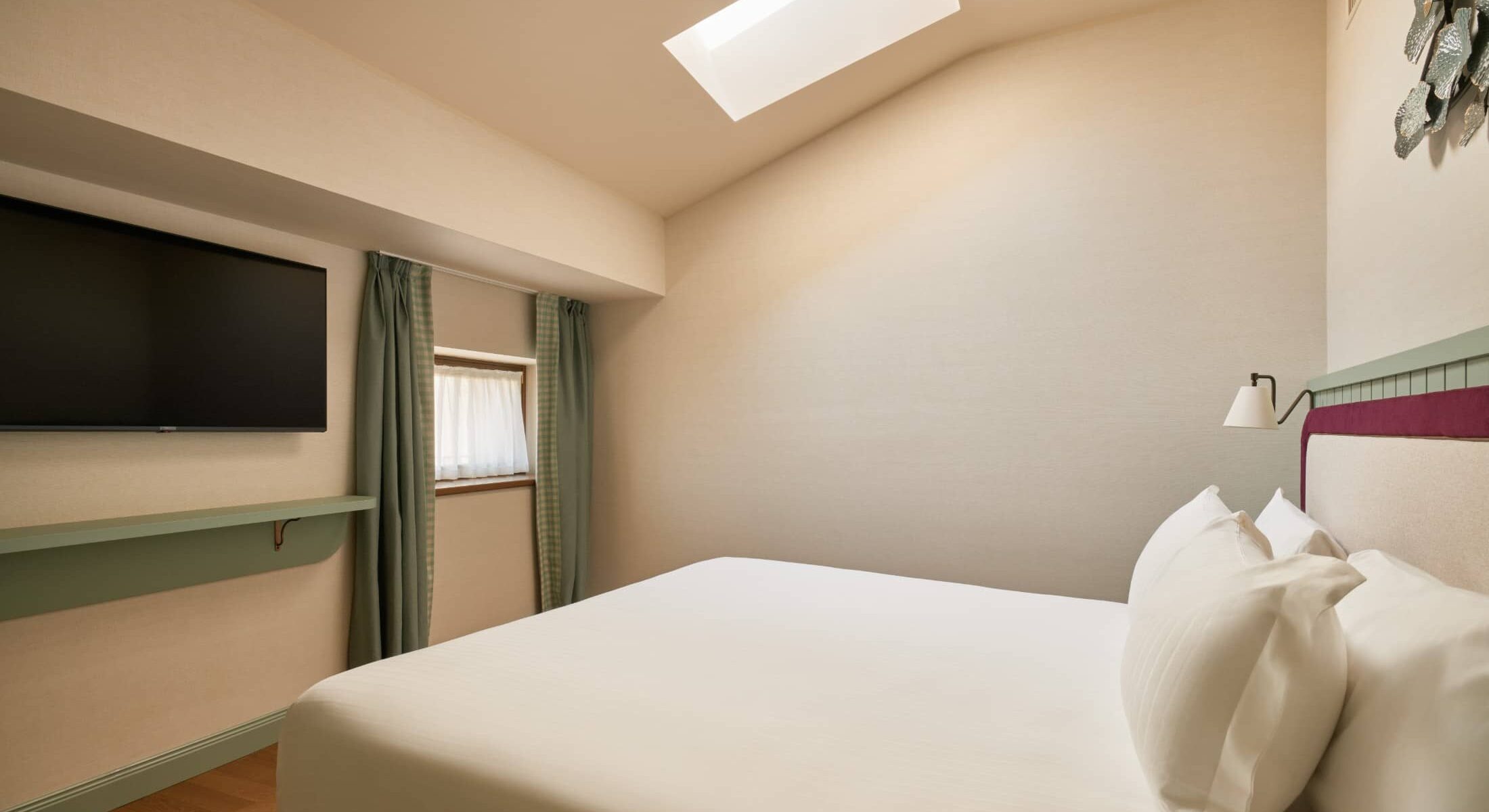 Camera mansardata con letto matrimoniale e lucernario – Homy Livia Verona