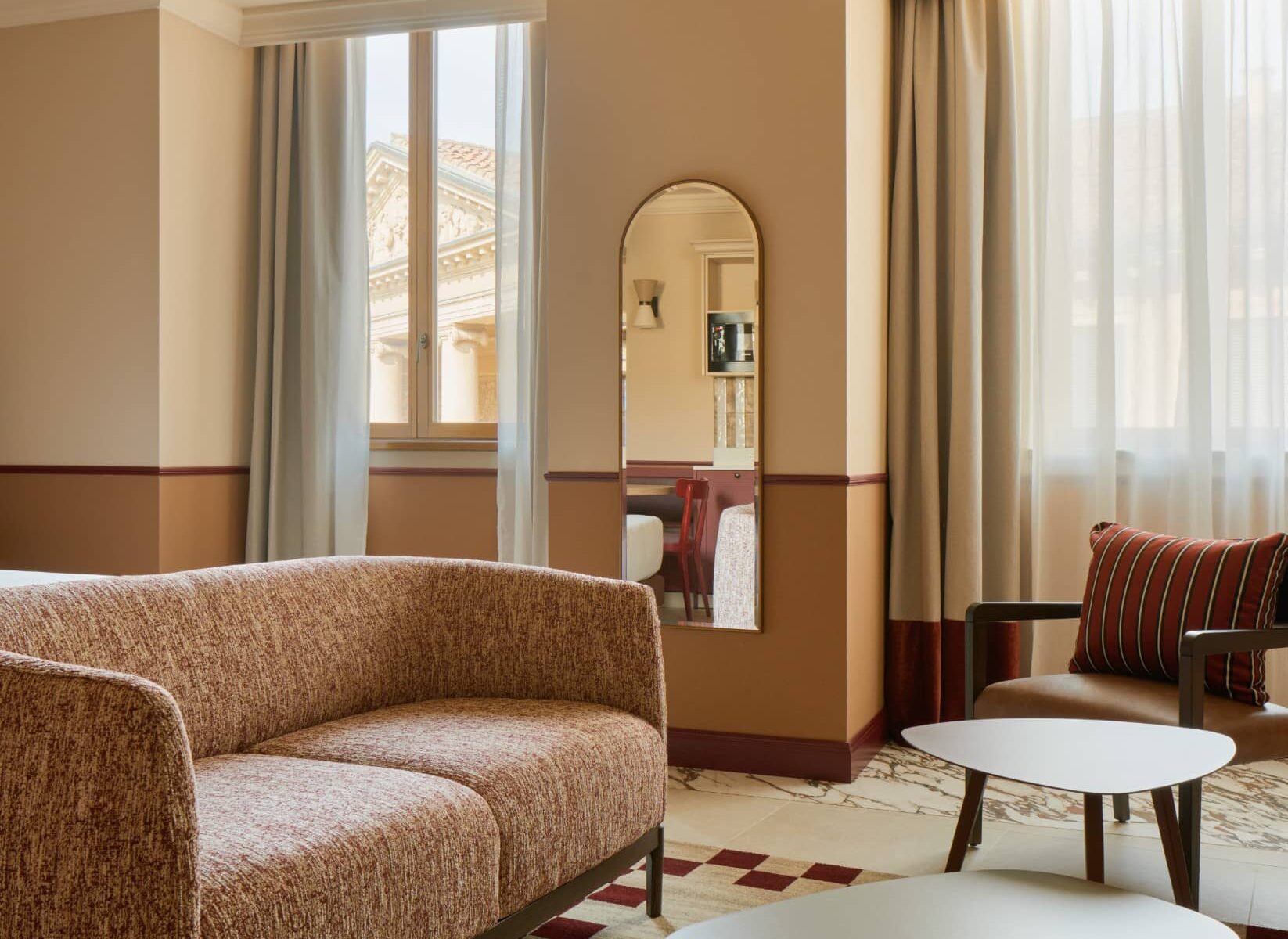 Soggiorno con ampie finestre e tavolini rotondi – Homy Livia Verona