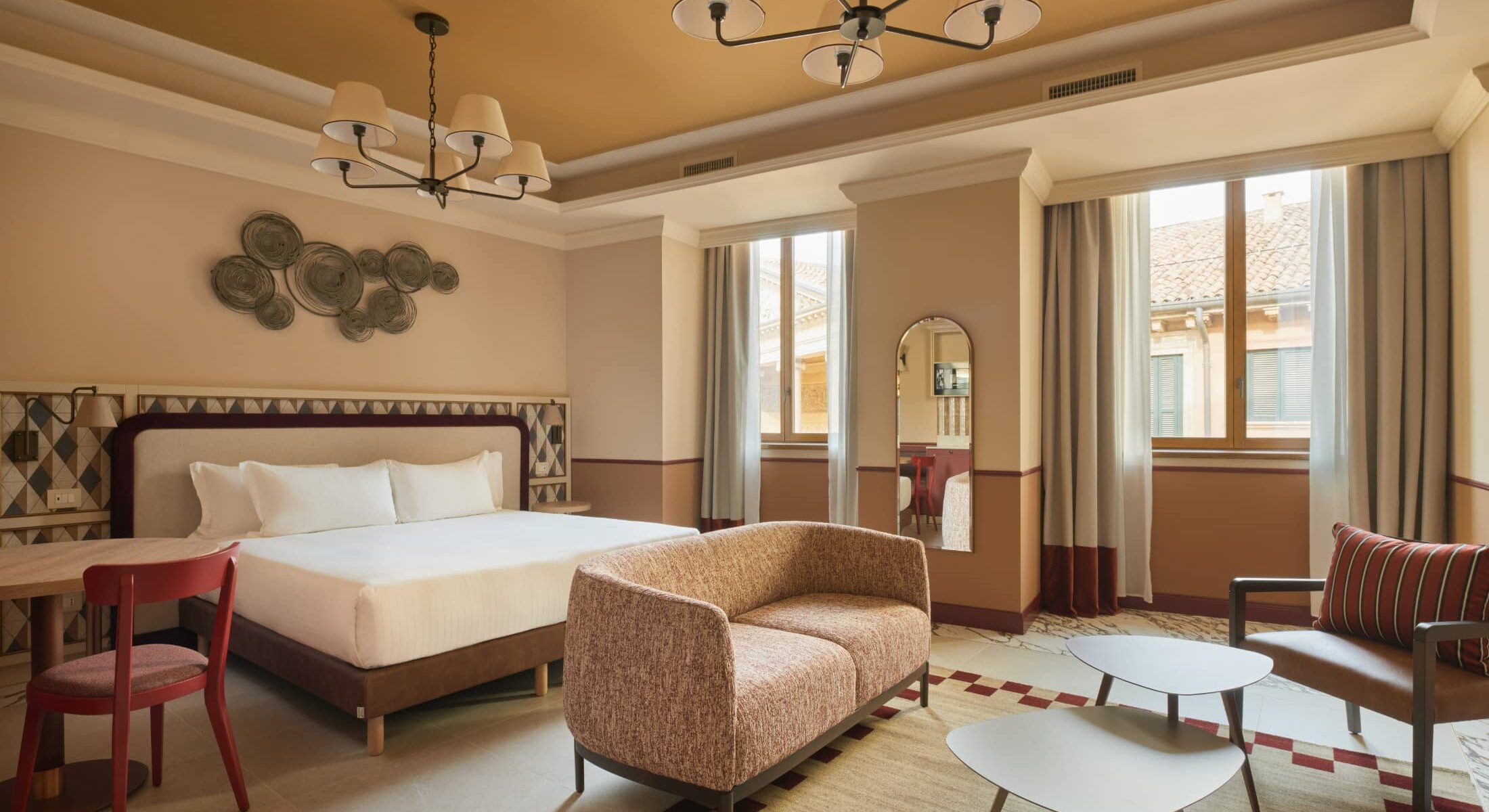 Camera con letto matrimoniale e divano imbottito ai piedi – Homy Livia Verona