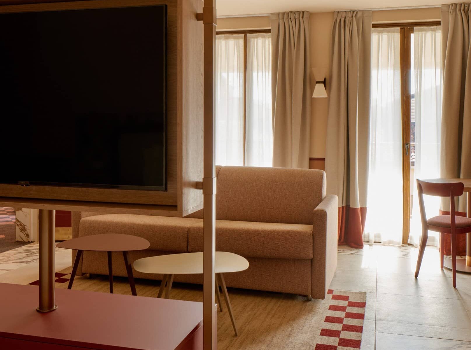 Soggiorno con divano color sabbia e TV a parete – Homy Livia Verona