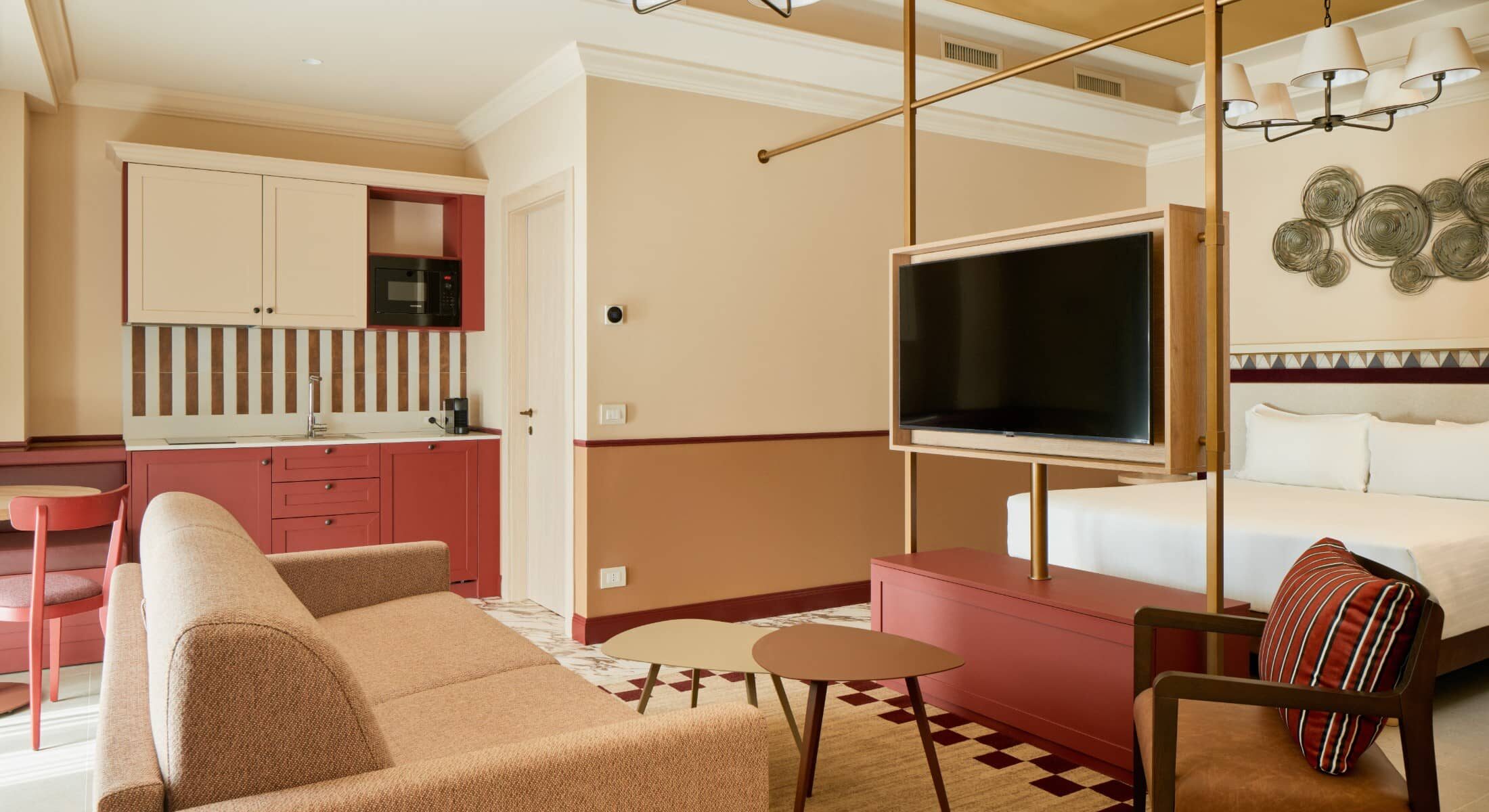 Soggiorno con divano beige, TV e pavimento con tappeto a scacchi – Homy Livia Verona