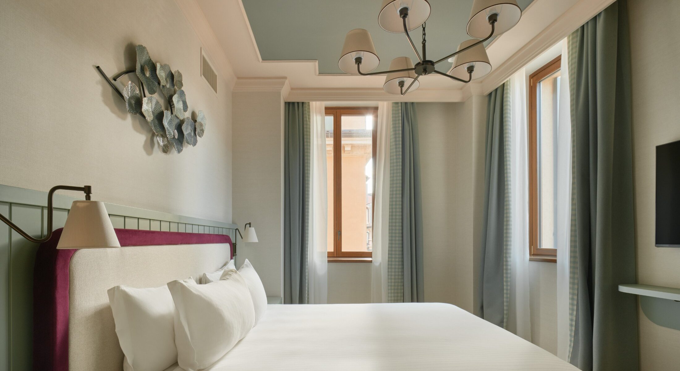 Camera matrimoniale con tende chiare e lampadario classico – Homy Livia Verona