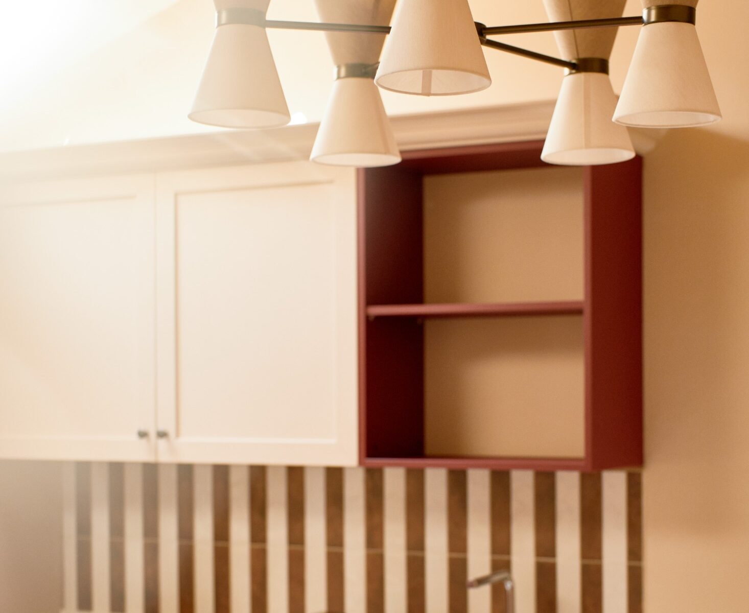 Dettaglio di cucina e lampadario su pareti beige – Homy Livia Verona